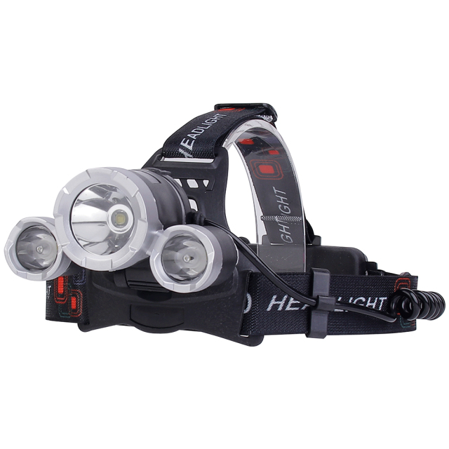 Three-quarter studio view of the three-lens head torch, displaying the integrated cylindrical lamp housings, pivoting mount, and the route of the coiled side power cable.