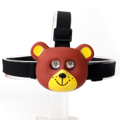 Studio front view of a brown and yellow cartoon bear-shaped custom kids head torch with dual embedded lights.