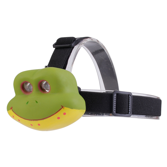 Three-quarter studio view of a green cartoon frog-shaped headlight module mounted on an adjustable elastic black headband.