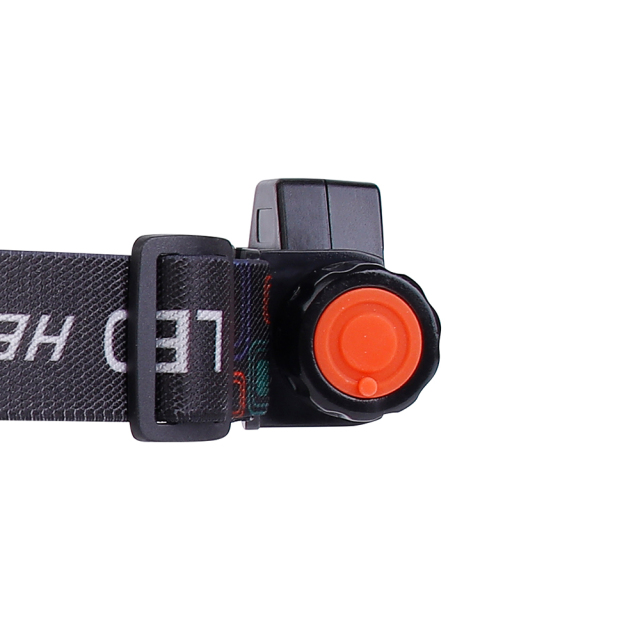Close-up studio view of the side profile highlighting the textured orange push-button power switch and the plastic adjustment loop on the black woven head strap.