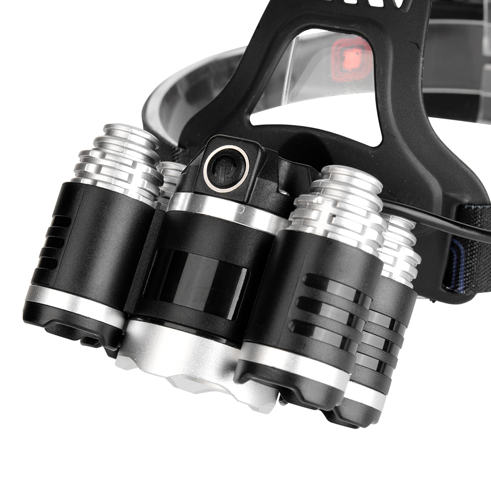 A close-up studio shot from a top-angled perspective, emphasizing the black and silver aluminum alloy housings of the multiple lenses integrated into the heavy-duty head torch module.