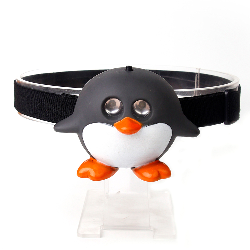 Studio front view of a custom black and white cartoon penguin-shaped kids head torch with dual glowing lenses.