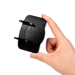 A studio photo of a person's hand holding the black clip-on caplight between their thumb and fingers, providing a clear size comparison to demonstrate its compact and lightweight scale.