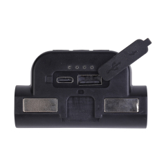 Studio close-up view of the headlamp's flat base, showing the two rectangular magnetic strips, four small green LED power indicator dots, and an opened rubber flap revealing the Type-C and USB ports.