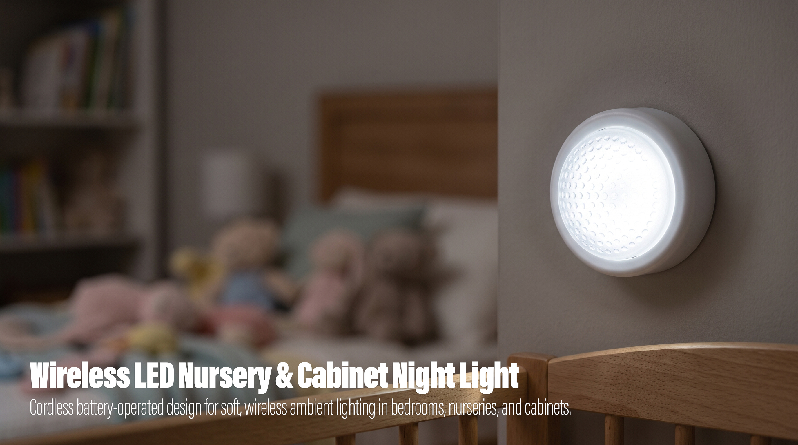 An illuminated white round wireless LED night light mounted vertically on a light gray wall, with a wooden crib rail in the foreground and a blurred child bedroom with plush toys in the background.