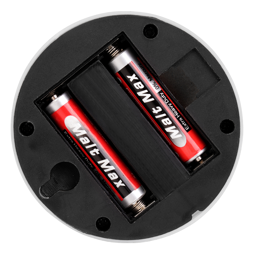 Studio view of the open black battery compartment on the back of the round light, showing two AAA batteries installed in parallel.
