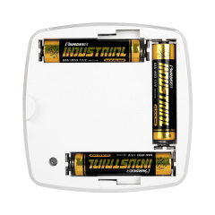 Studio view of the open battery compartment on the back of the puck light, showing three AAA yellow and black batteries installed inside the plastic housing slots.