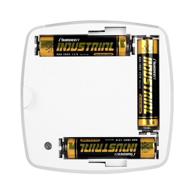 Studio view of the open battery compartment on the back of the puck light, showing three AAA yellow and black batteries installed inside the plastic housing slots.