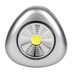 Studio front view of a silver triangular wireless puck light featuring a large circular COB LED panel with a yellow center.