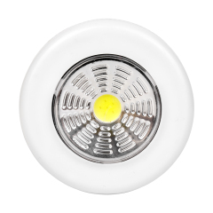 Studio front view of a white round wireless puck light featuring a large circular COB LED panel with a yellow center.