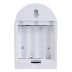 Studio view of the open internal battery compartment on the back of the arched night light, showing contact springs for four AA batteries.
