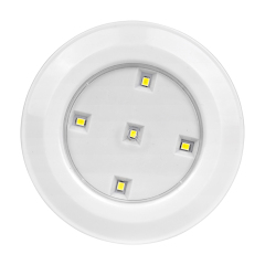 Studio straight front view of the circular LED puck light, featuring five individual small LED diodes arranged symmetrically on a silver reflector plate inside the white housing.