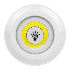 Studio straight front view of the circular LED puck light, featuring a yellow COB light ring surrounding a central white push button with a light bulb icon.