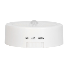 Studio side profile view of the circular night light, showing a three-way slider switch with labels for AUTO, OFF, and ON.
