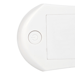 Close-up studio view of the back of the white night light, showing a small debossed circular power button next to the edge.