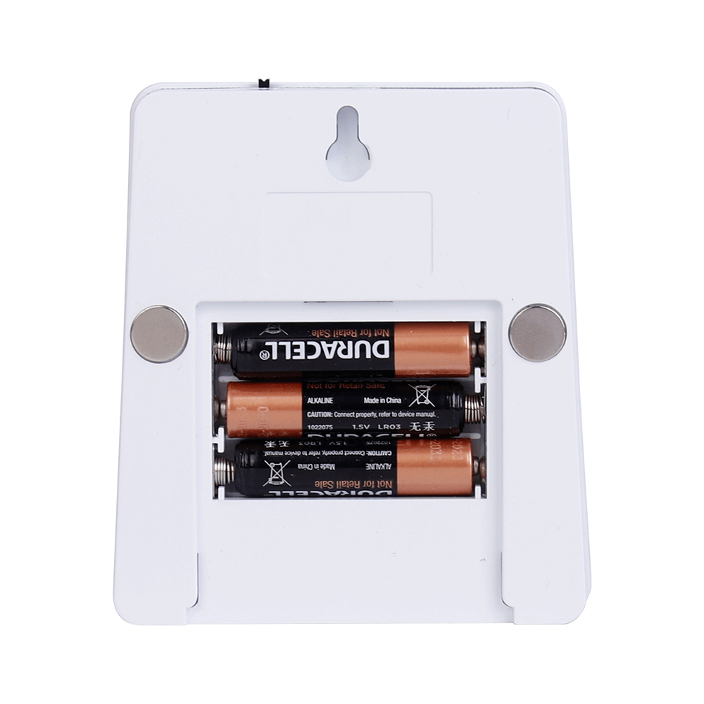 Studio back view of the white night light with the battery compartment open, showing three AAA batteries installed inside the housing.