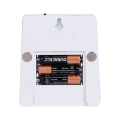Studio back view of the white night light with the battery compartment open, showing three AAA batteries installed inside the housing.