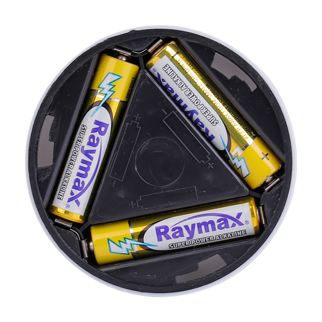 Studio view of the opened round cabinet light housing, exposing the internal triangle-arranged compartment with three AAA batteries installed.