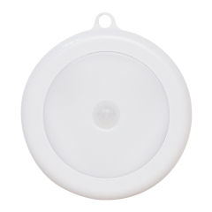 A direct front view of the round white PIR motion sensor LED night light on a clean white background, showcasing its dome diffuser and central sensor.