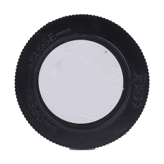 Studio back view of the round cabinet light, displaying a black twist-on cover with a white adhesive pad and embossed open and close arrow indicators.