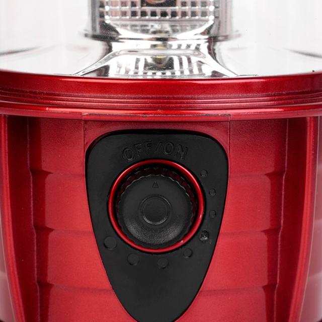 Close-up macro shot of the black rotary dimmer switch embedded in the red body of the dimmable camping lantern.