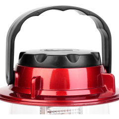 Close-up view of the black plastic carrying handle and the red metallic finish top cap of the portable retro camping lantern.