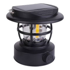 An angled front view of the black retro COB LED lantern showcasing the protective iron guard rails and the front stepless dimming rotary knob.