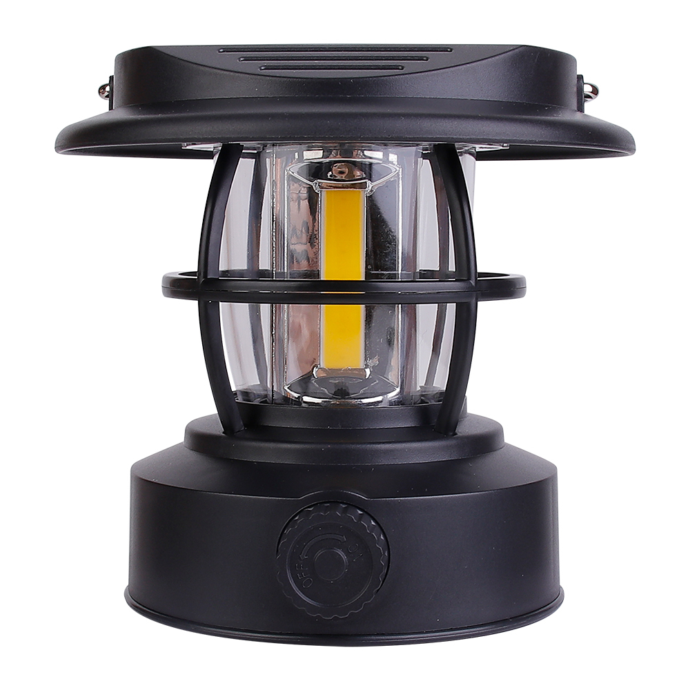 Direct front view of the black solar vintage camping lantern on a white background, displaying its compact hat-shaped top and central COB LED bulb.