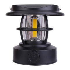 Direct front view of the black solar vintage camping lantern on a white background, displaying its compact hat-shaped top and central COB LED bulb.