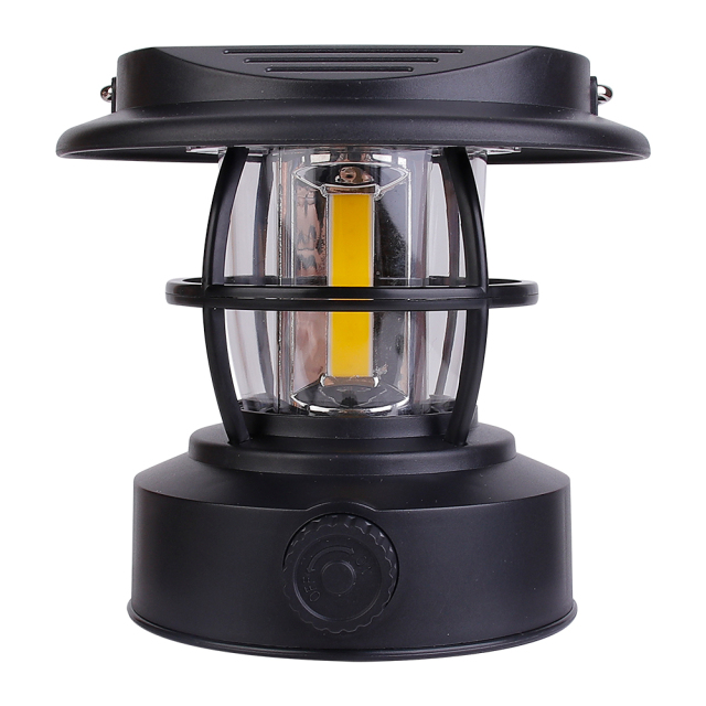 Direct front view of the black solar vintage camping lantern on a white background, displaying its compact hat-shaped top and central COB LED bulb.