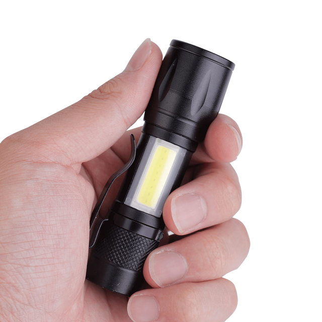 A person holding the compact black aluminum LED flashlight in one hand to show its small pocket size.