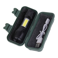 The compact black LED flashlight and USB charging cable organized in a green protective plastic box.