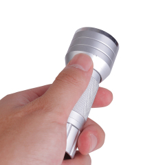 A hand holding the compact silver aluminum flashlight to demonstrate its portable size and anti-slip textured grip.