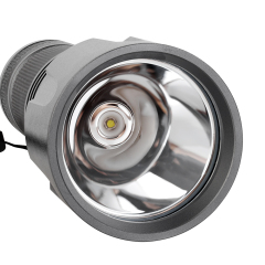 A close-up shot of the aluminum flashlight's deep polished reflector cone and central LED bulb.
