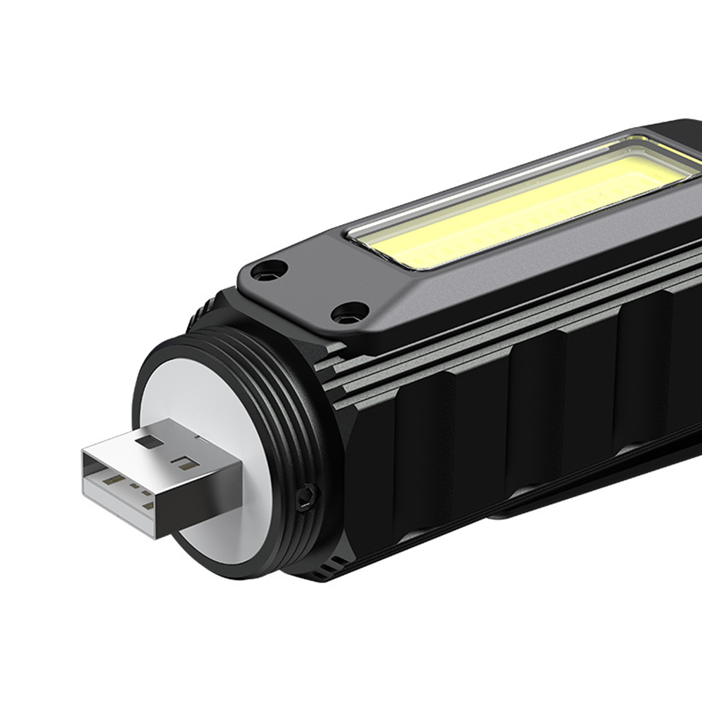 A close-up view of the flashlight with its tail cap unscrewed, revealing the integrated USB charging plug.