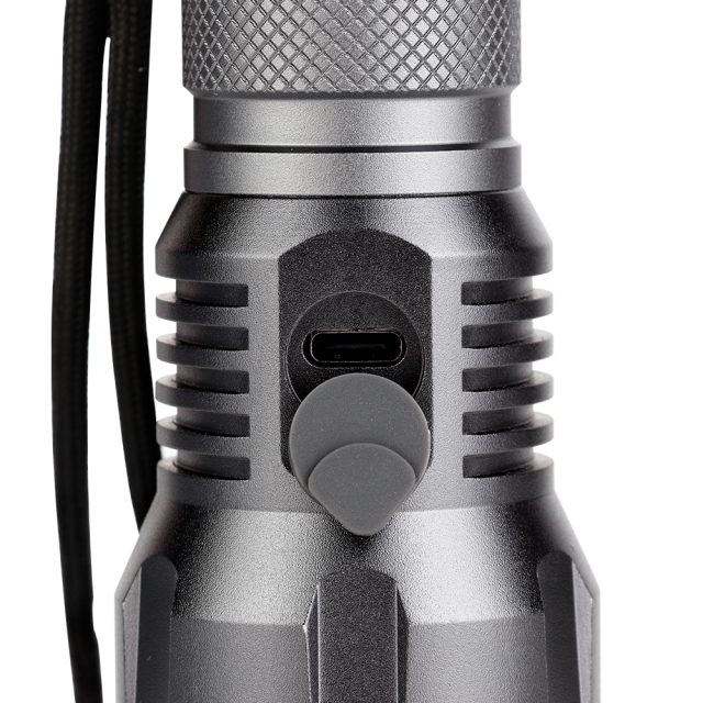 Close-up view of the rubber dust cover protecting the Type-C USB charging port on the flashlight body.