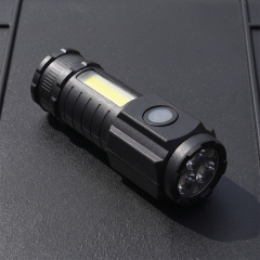 A black mini rechargeable flashlight with 3 LED front bulbs and a side COB floodlight panel lying on a dark surface.