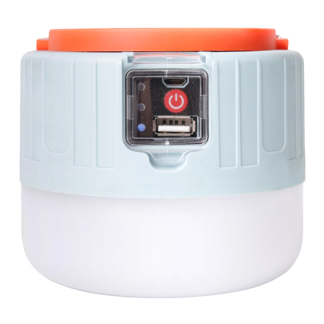 Front view of the rechargeable solar camping light with its orange handle folded down, showcasing the power button and USB port.