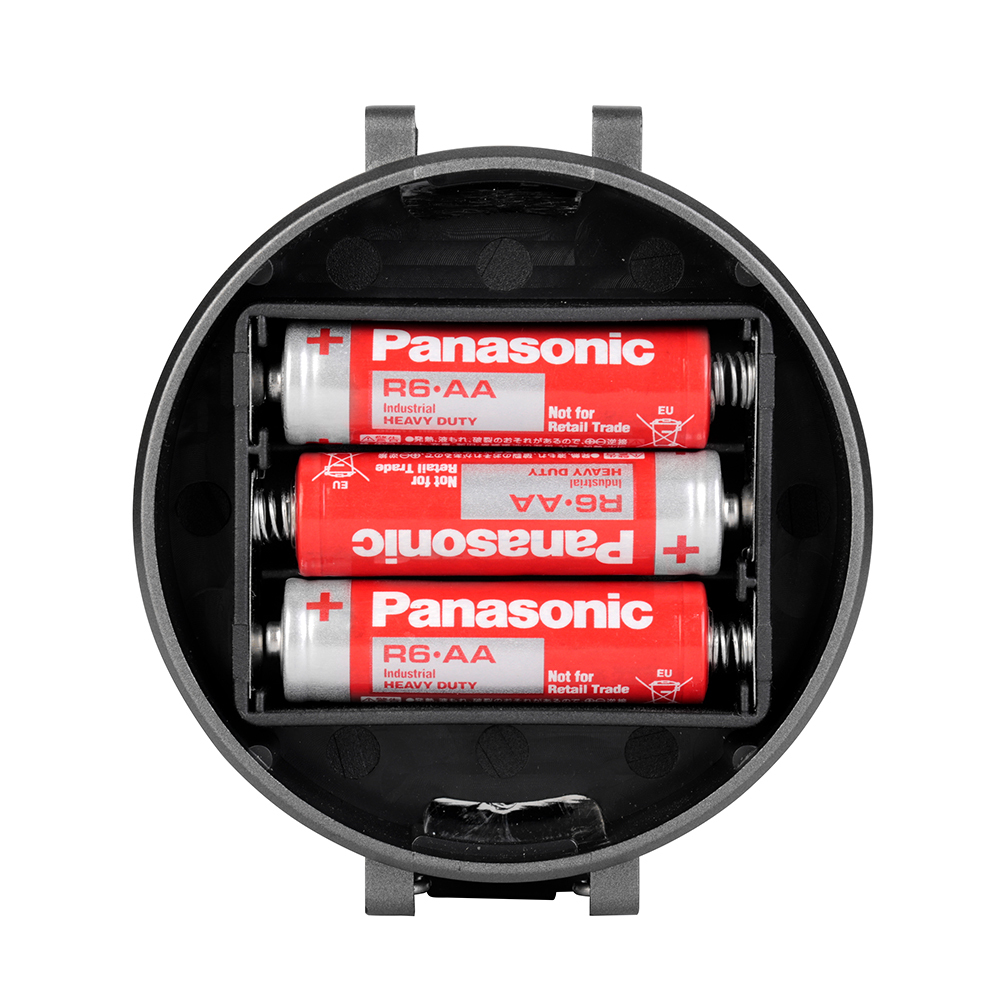 Bottom-up view of the opened battery compartment with three AA batteries inside the lantern.