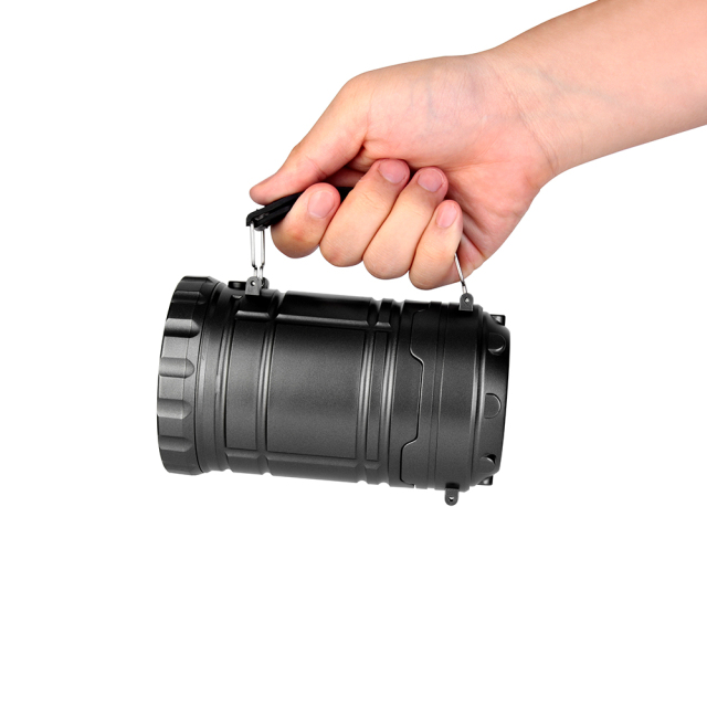 A hand holding the collapsible camping lantern horizontally using the handle as a flashlight.