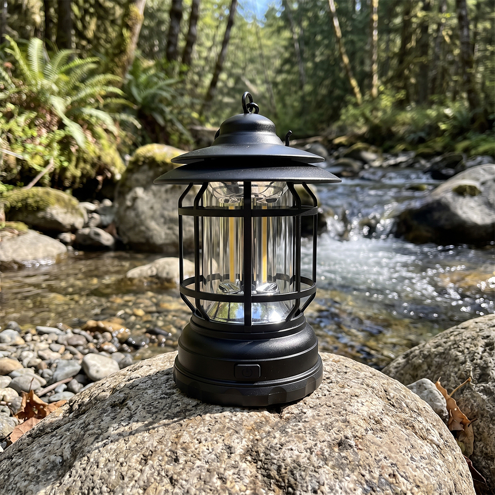 A black vintage COB LED camping lantern sitting on a rock by a mountain stream.