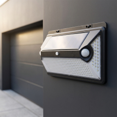 A high-brightness solar motion sensor outdoor light mounted on a concrete wall outside a garage.
