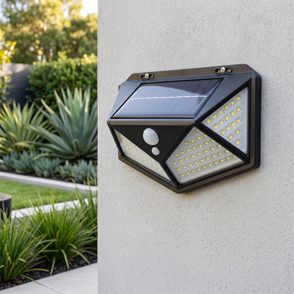 A wide-angle solar motion sensor outdoor wall light mounted on a concrete wall in a daytime garden.