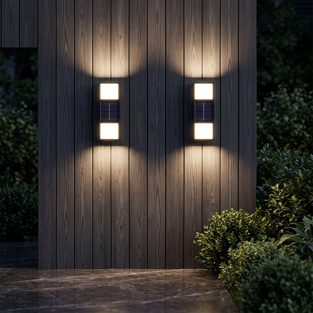Two solar fence wall lights casting warm up and down light beams on a vertical wooden wall at night.
