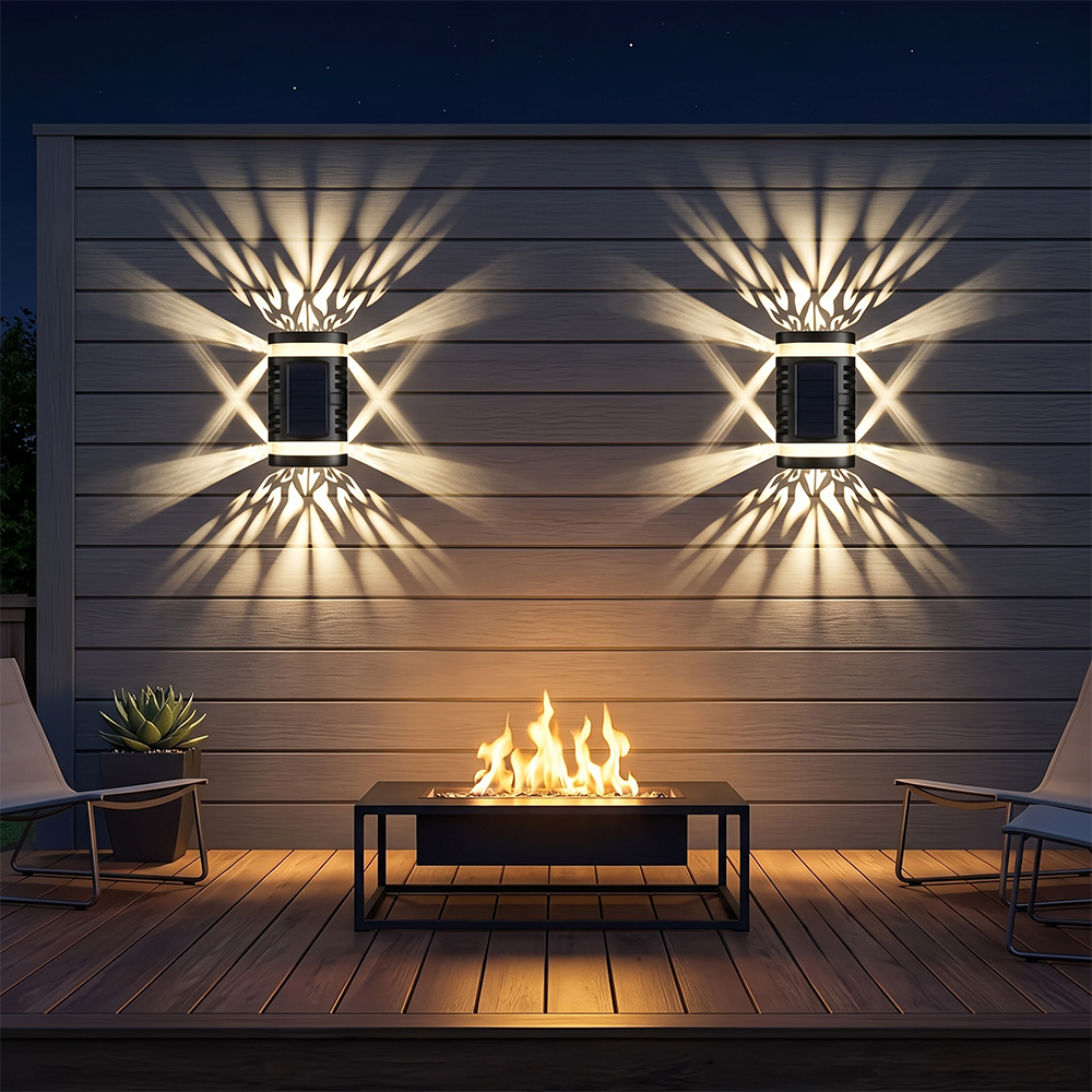 Two solar pattern wall lights casting decorative warm light beams on a wooden patio wall with a fire pit.