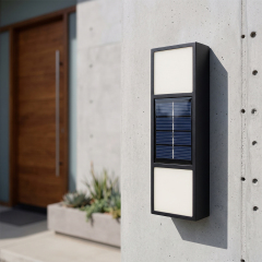 A black rectangular solar up and down wall light mounted on a modern light gray concrete wall during daytime.