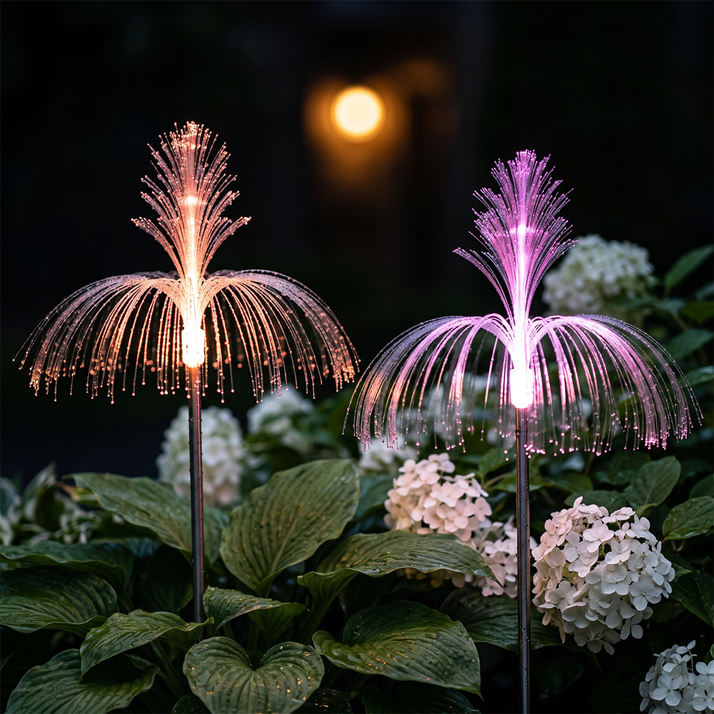 Close-up of orange and purple solar optical fiber fountain lights glowing brightly in a garden at night.