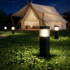 Solar pathway bollard lights glowing on a dark green lawn in front of an illuminated camping tent.