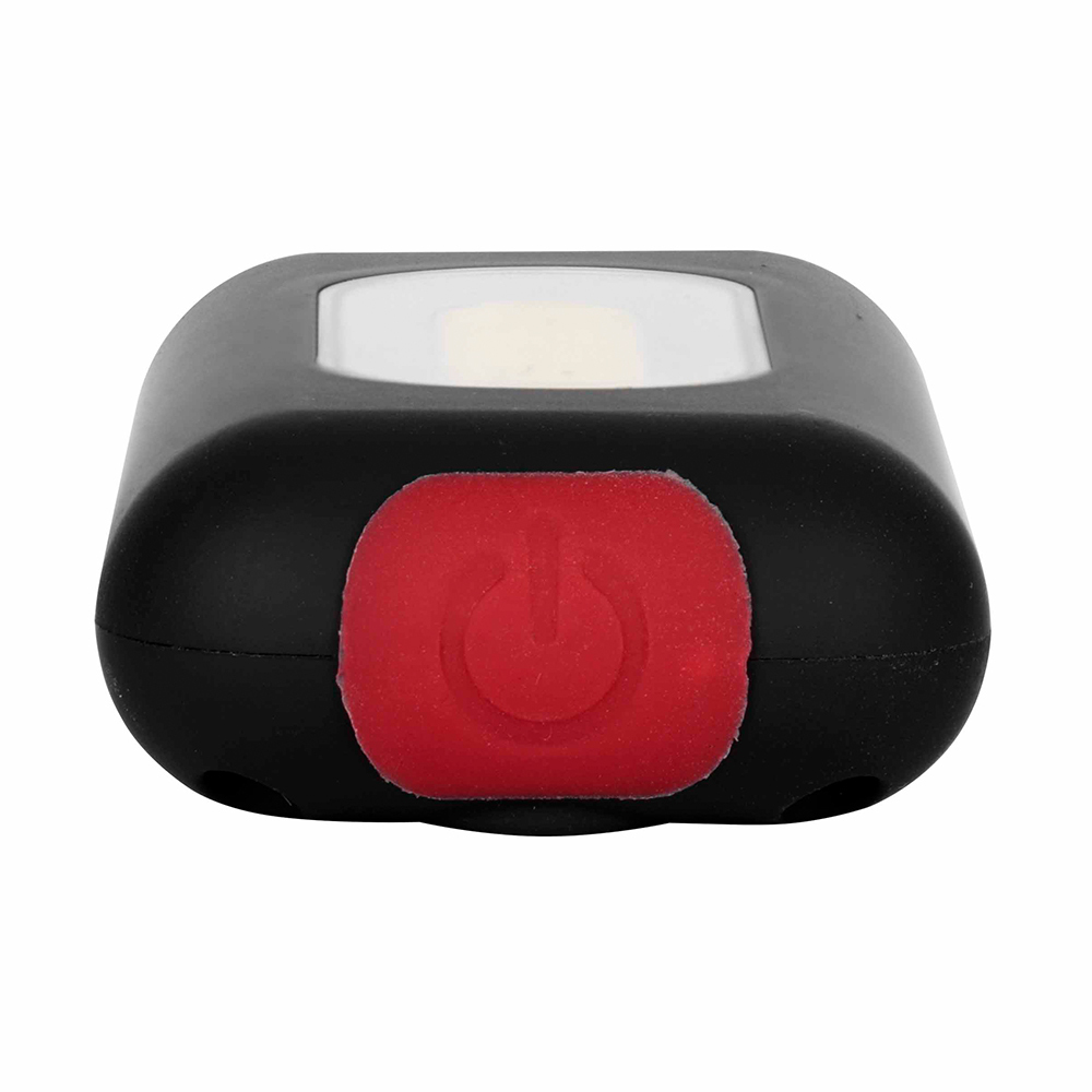 Close-up view of the red push button switch on the bottom of a black COB keychain light.