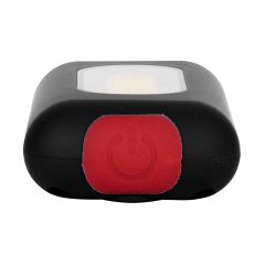 Close-up view of the red push button switch on the bottom of a black COB keychain light.